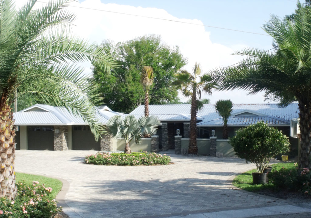 Sunny courtyard with palm trees and a circular garden bed.