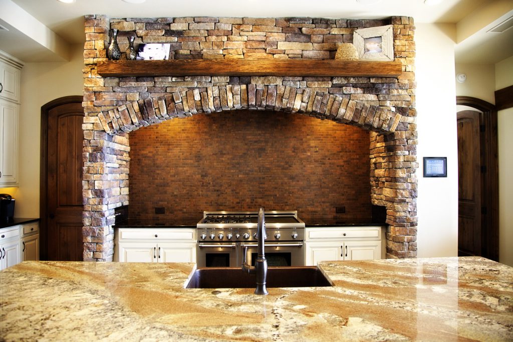 Rustic kitchen nook with stone arch and modern sink.