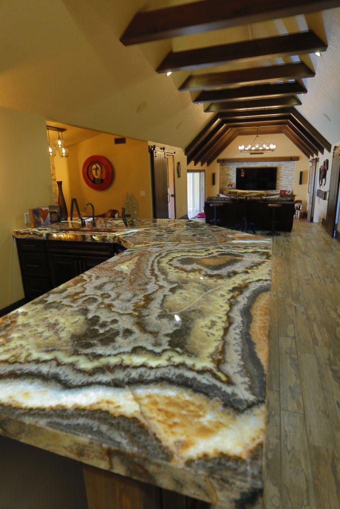 Elegant kitchen with a polished, patterned stone countertop and warm lighting.