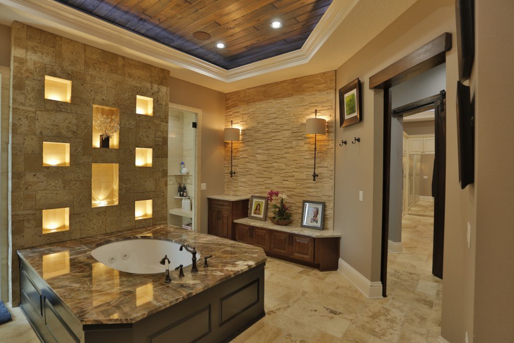 Luxurious bathroom with a large soaking tub and elegant stone decor.
