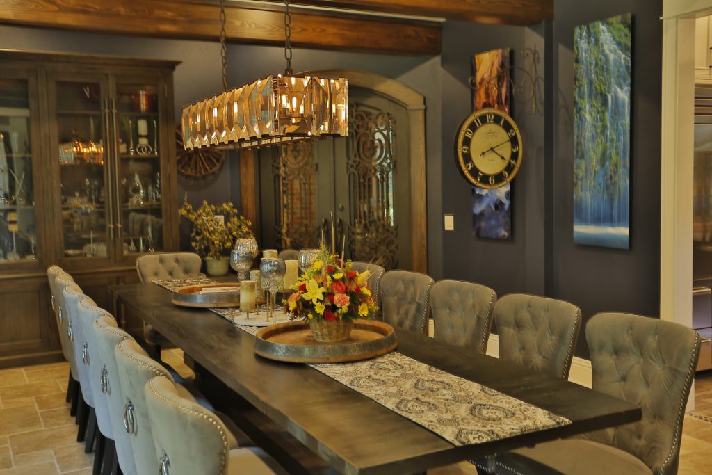 Elegant dining table set with floral centerpiece and hanging glass rack.
