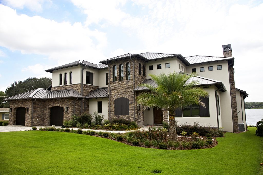 Elegant two-story house with stone accents and lush landscaping.