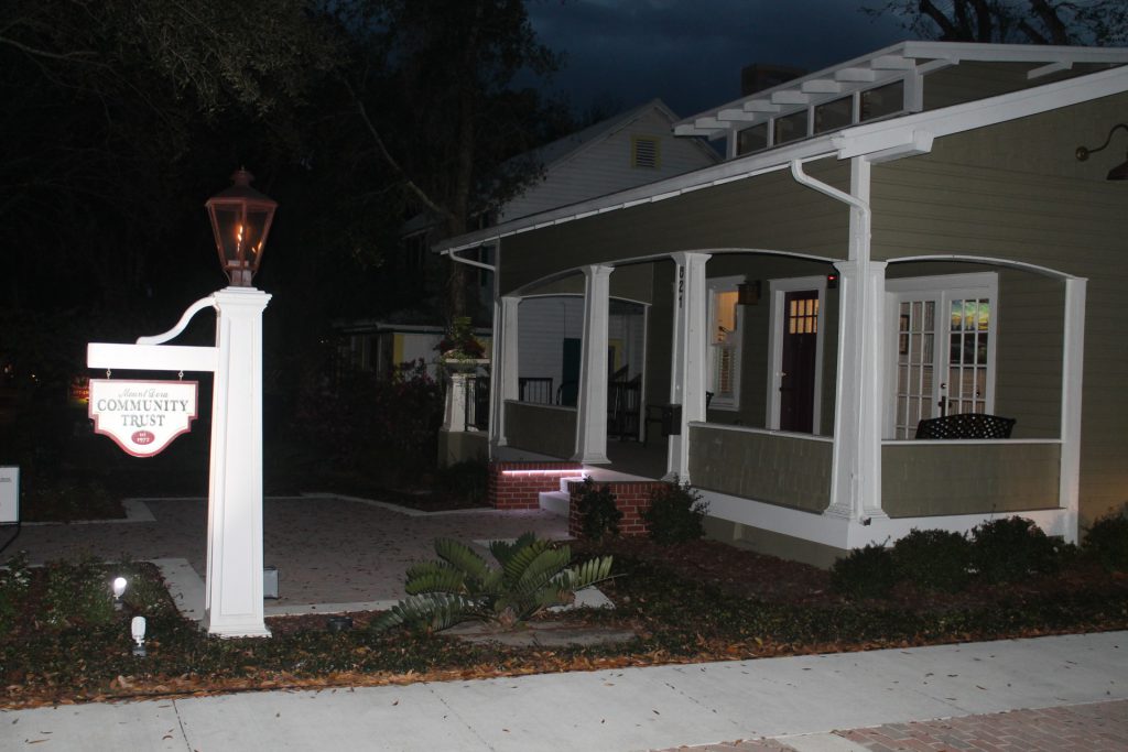 A cozy house porch lit warmly at night.
