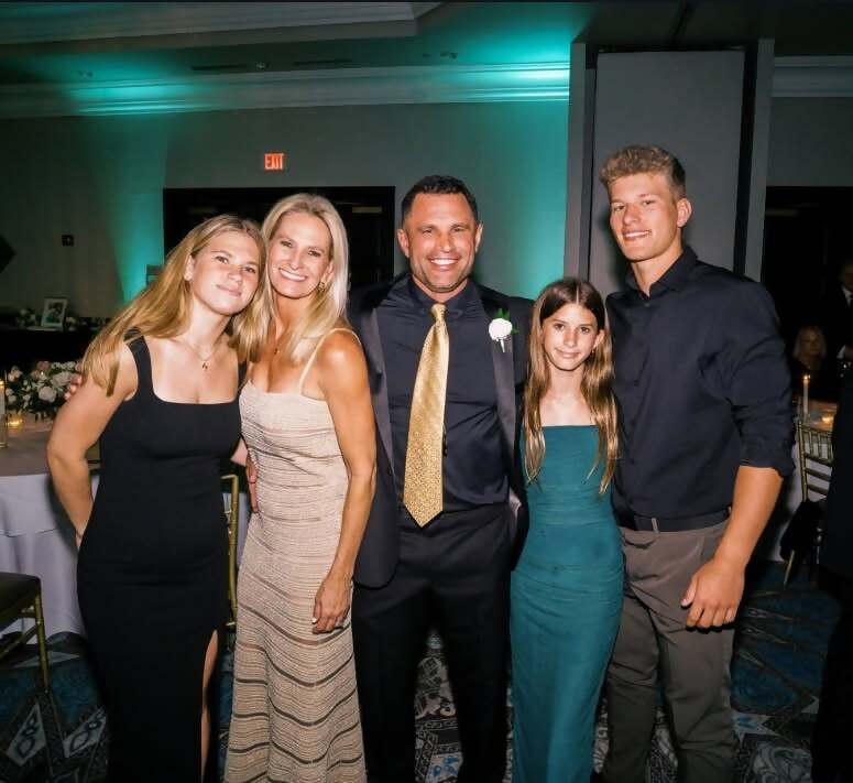 A smiling couple standing outdoors, dressed casually.